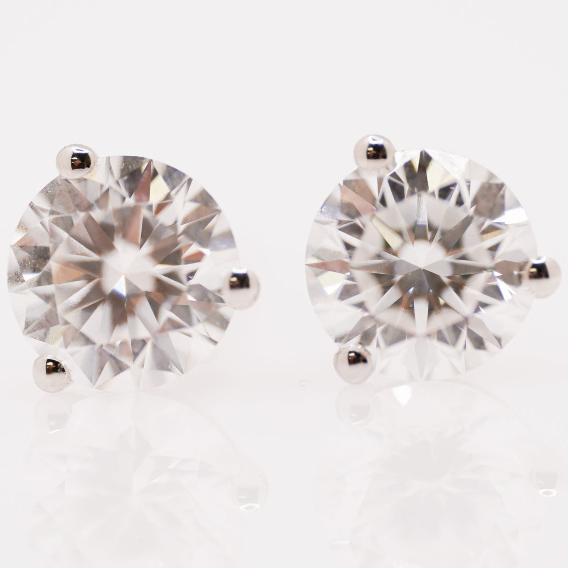 Pair of diamond stud earrings on a light background